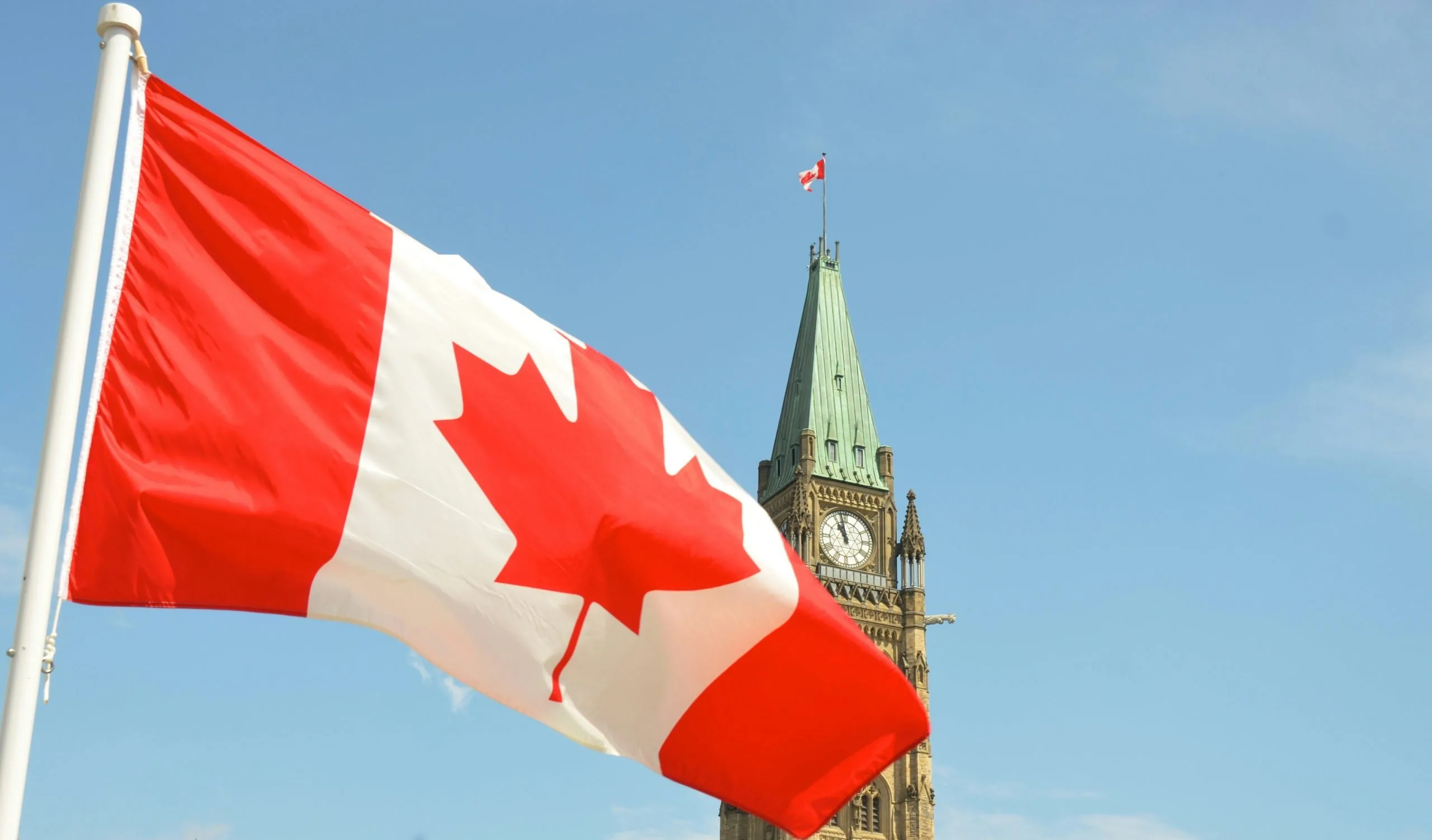 Canadian flag flying beside Parliament Hill in Ottawa